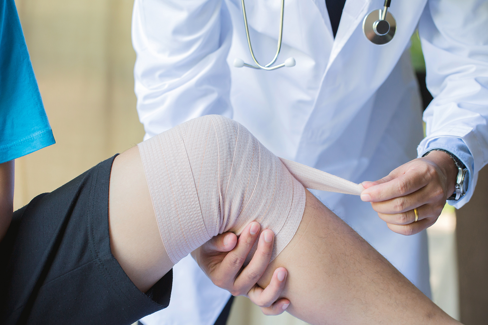 Physician wrapping Patient Knee
